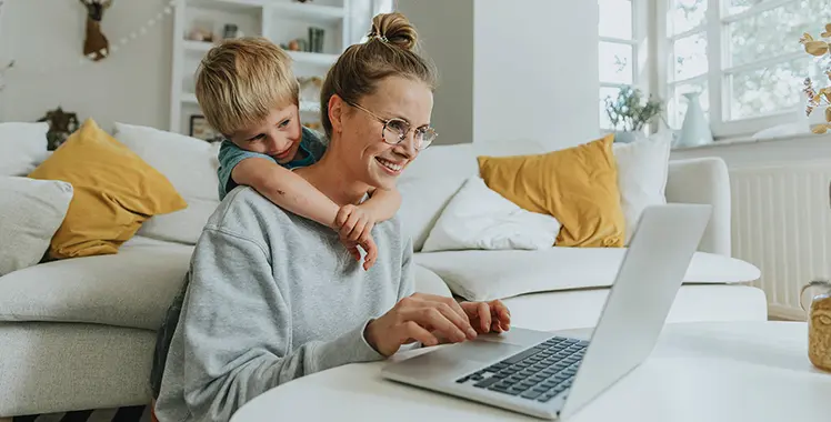 Person on a laptop at home with child