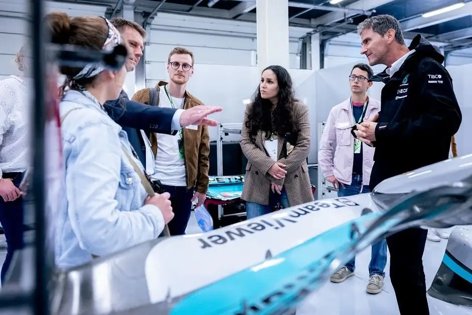 Group of employees receiving presentation about F1 car